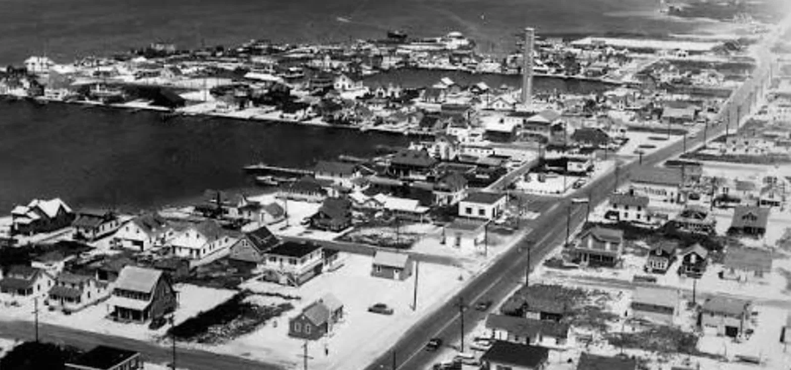 Vintage black and white aerial view of Harvey Cedars, with homes, the bay, and Long Beach Boulevard